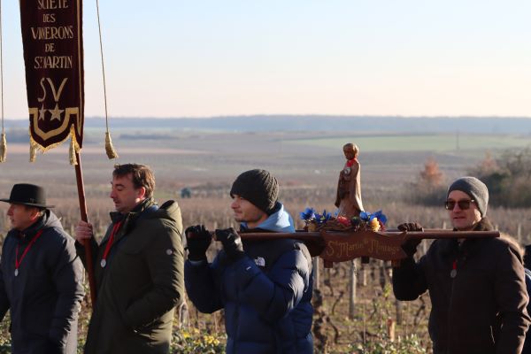 Le Saint-Vincent, précédé de l'étendard et vue sur les vignes